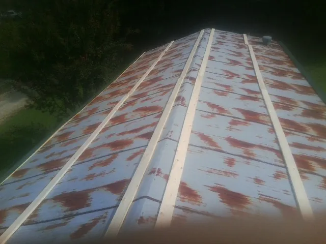 Rusted metal roof panels with new wood purlins before replacement in Unionville